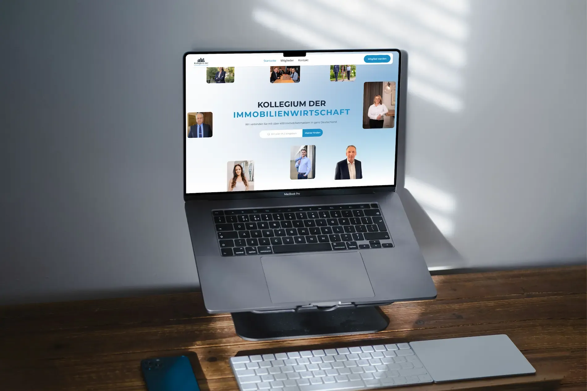 Laptop auf Holztisch zeigt die Startseite der Website des Kollegiums für Immobilienmakler